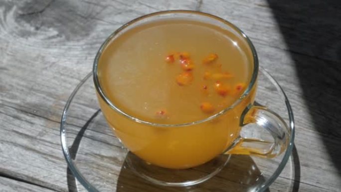 沙棘浆果漂浮在玻璃杯中的沙棘茶表面