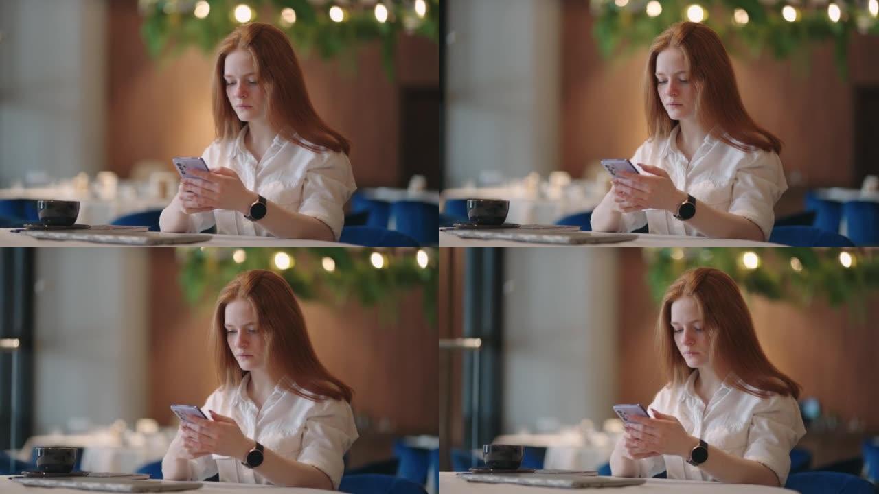 红发女人在家工作时使用笔记本电脑，同时在手机上阅读短信。女人用电话。认真迷人的女人在家里使用笔记本电