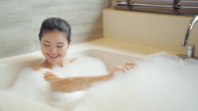 女人在浴缸里泡泡浴。