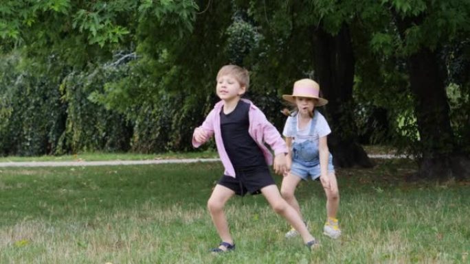 有趣的孩子一起在公园草地上跳舞跳跃玩得开心