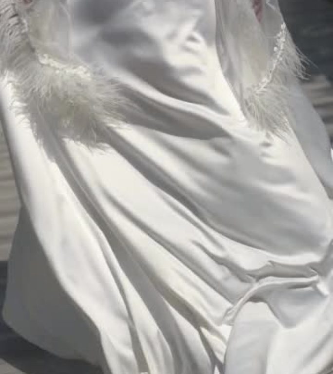 垂直夹。新娘穿着漂亮的拖尾婚纱浴袍，沿着桥走。慢性