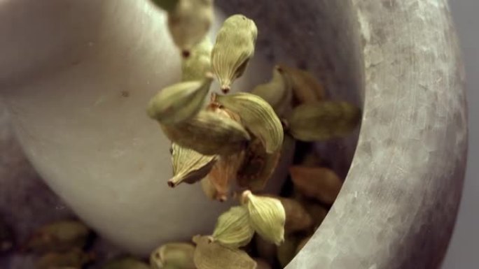 花岗岩砂浆和豆蔻香料物种在慢动作中掉落