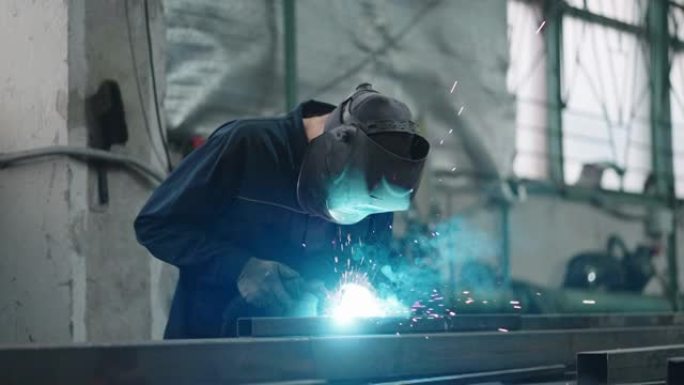 防护面罩中的工作焊机以慢动作将金属零件与气体或电焊连接起来