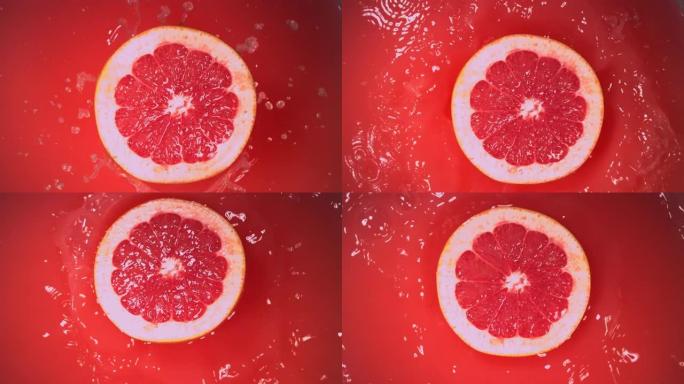 新鲜的半葡萄柚在慢动作中掉落在果汁中