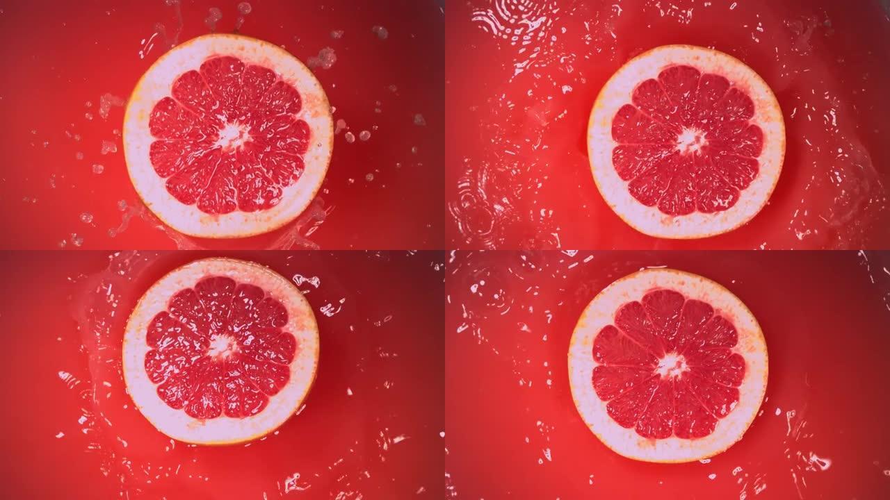 新鲜的半葡萄柚在慢动作中掉落在果汁中