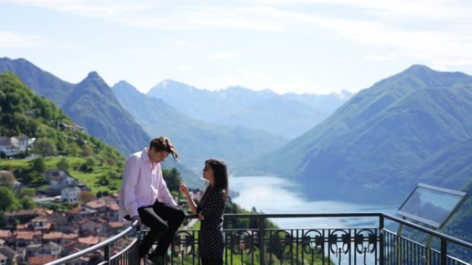 年轻夫妇一起欣赏湖泊和山脉的景色，调情