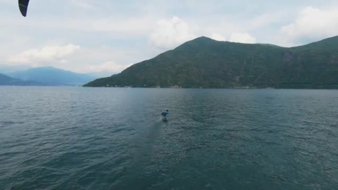 空中无人机拍摄了一名男子在山上的湖上冲浪的风