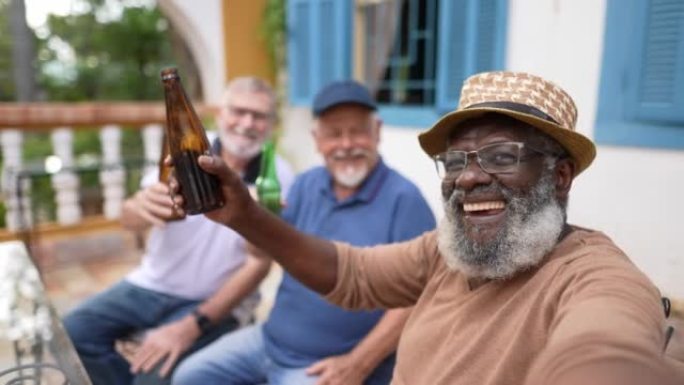 资深男子喝啤酒时在手机上自拍-观点