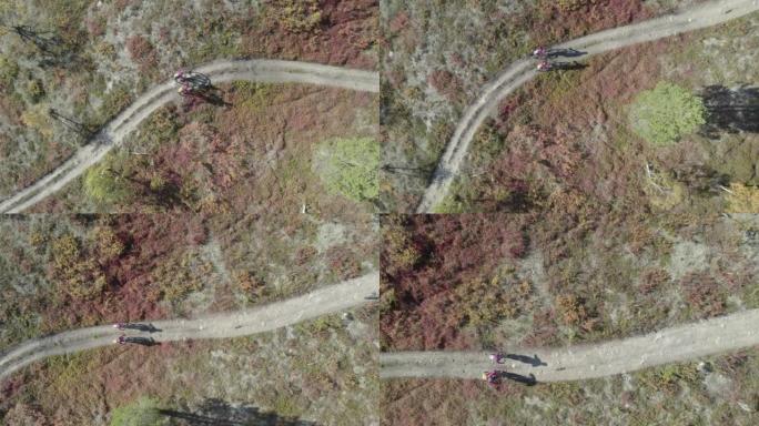 在广阔的荒野中，一对山地自行车夫妇的空中无人机拍摄