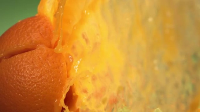 绿色自然背景下慢动作的新鲜橙色水果喷射果汁4K