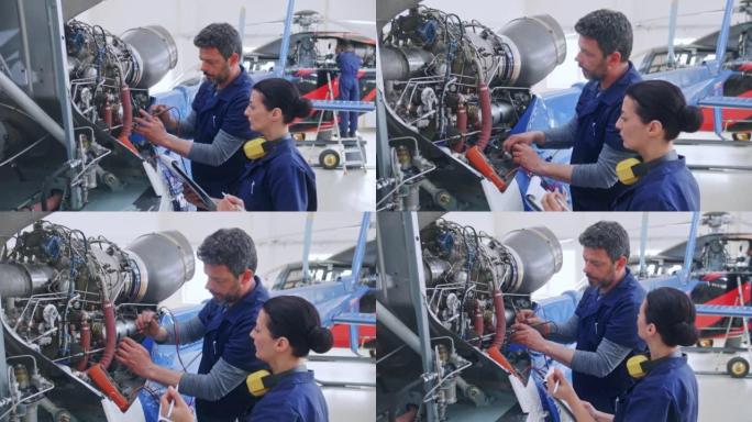 DS高级航空机械师在直升机发动机上工作时教他的女学徒