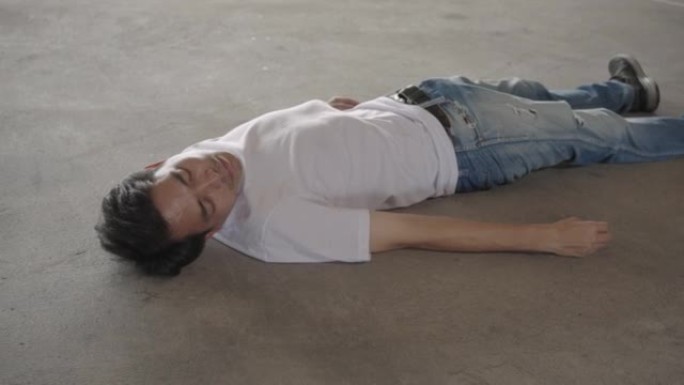由于酷热，中暑，全球变暖，男子昏迷不醒地躺在水泥地板上。