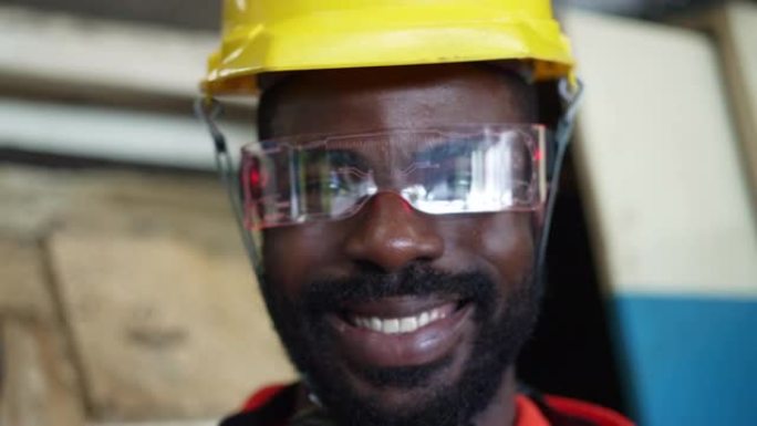 肖像专业机械工程安全安全帽头盔和微笑看相机在金属工厂。
