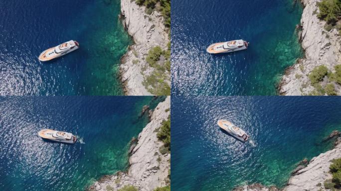 空中人员在岩石海滩停泊的游艇旁游泳