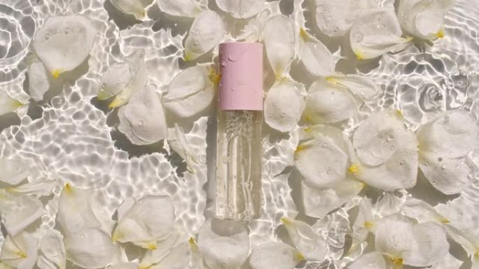 玫瑰花瓣在水面上开花，水滴。化妆瓶，油，液体，胶原蛋白血清小瓶。女性化妆品护肤品。布局美容产品样本。