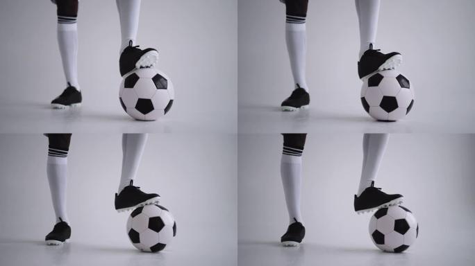 工作室里穿着靴子和膝盖袜子的足球球和腿，特写镜头