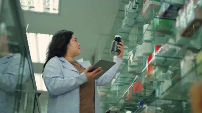 女药剂师在药房用数字平板电脑检查货架