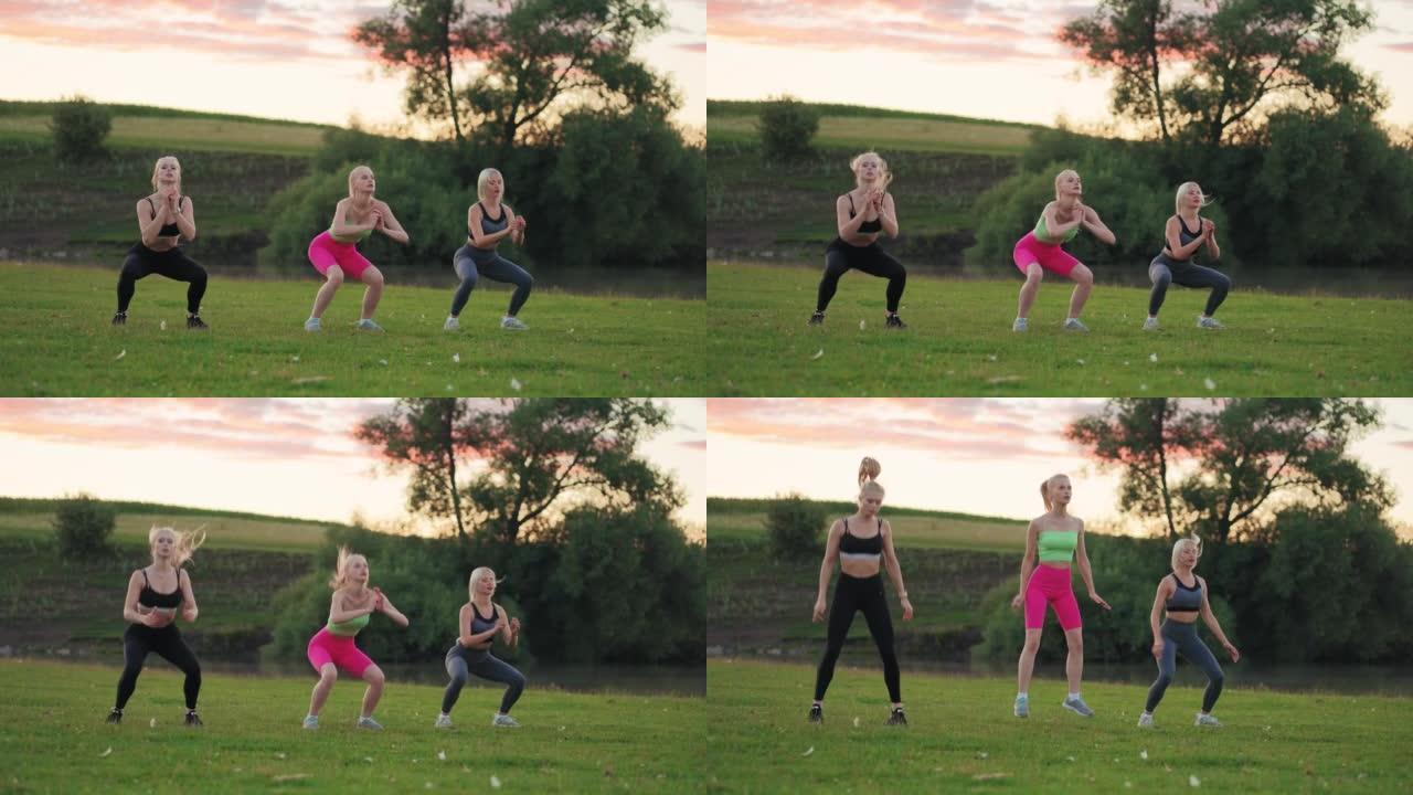 健身模特女子跳跃和蹲着，三位运动女士正在公园户外训练，锻炼臀部