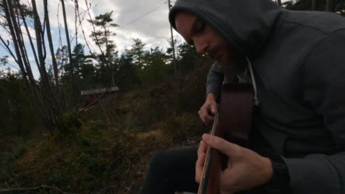POV男子在大自然户外演奏原声吉他