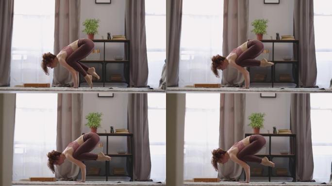 女运动员早上在家表演体式，用手将身体从地板上抬起，进行体育锻炼