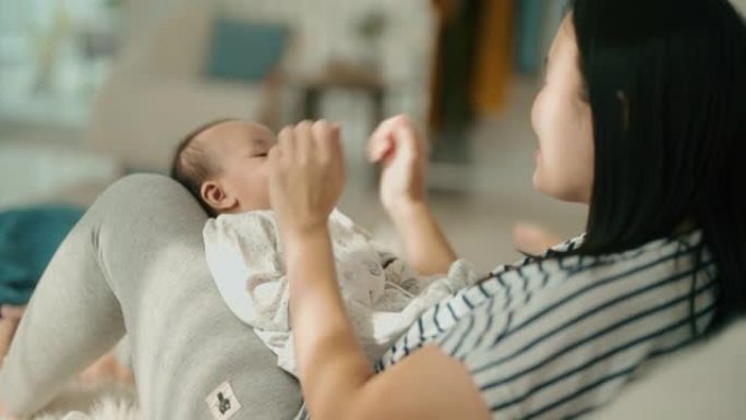 亚洲母亲与她的两个男婴蹒跚学步的孩子在家里交往时间