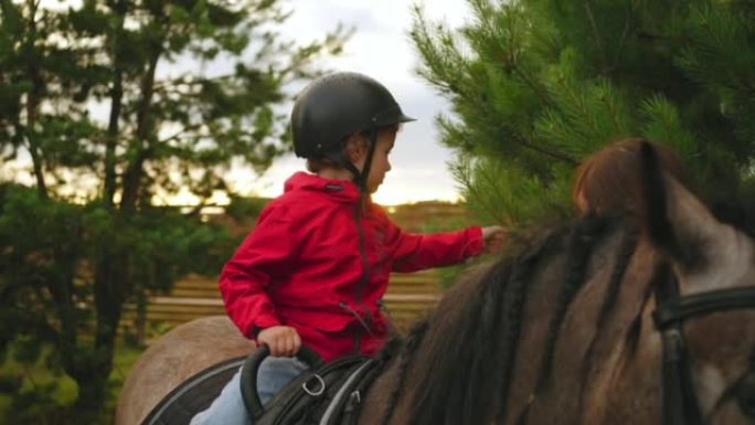 在大自然中，孩子们骑马，可爱的蹒跚学步的孩子坐在小马背上，在森林里散步