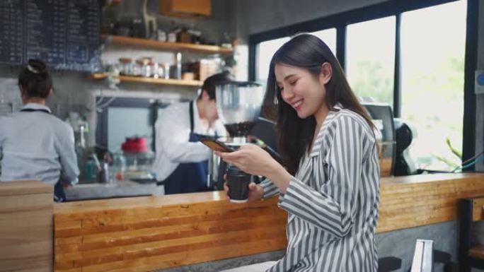 快乐的企业主在咖啡馆使用智能手机