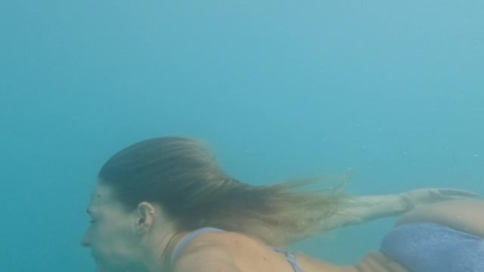 年轻女子在清澈的海水中游泳的第一人称视角