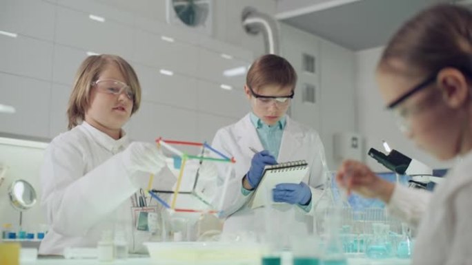 孩子们在实验室进行科学实验。用肥皂泡液体研究表面张力
