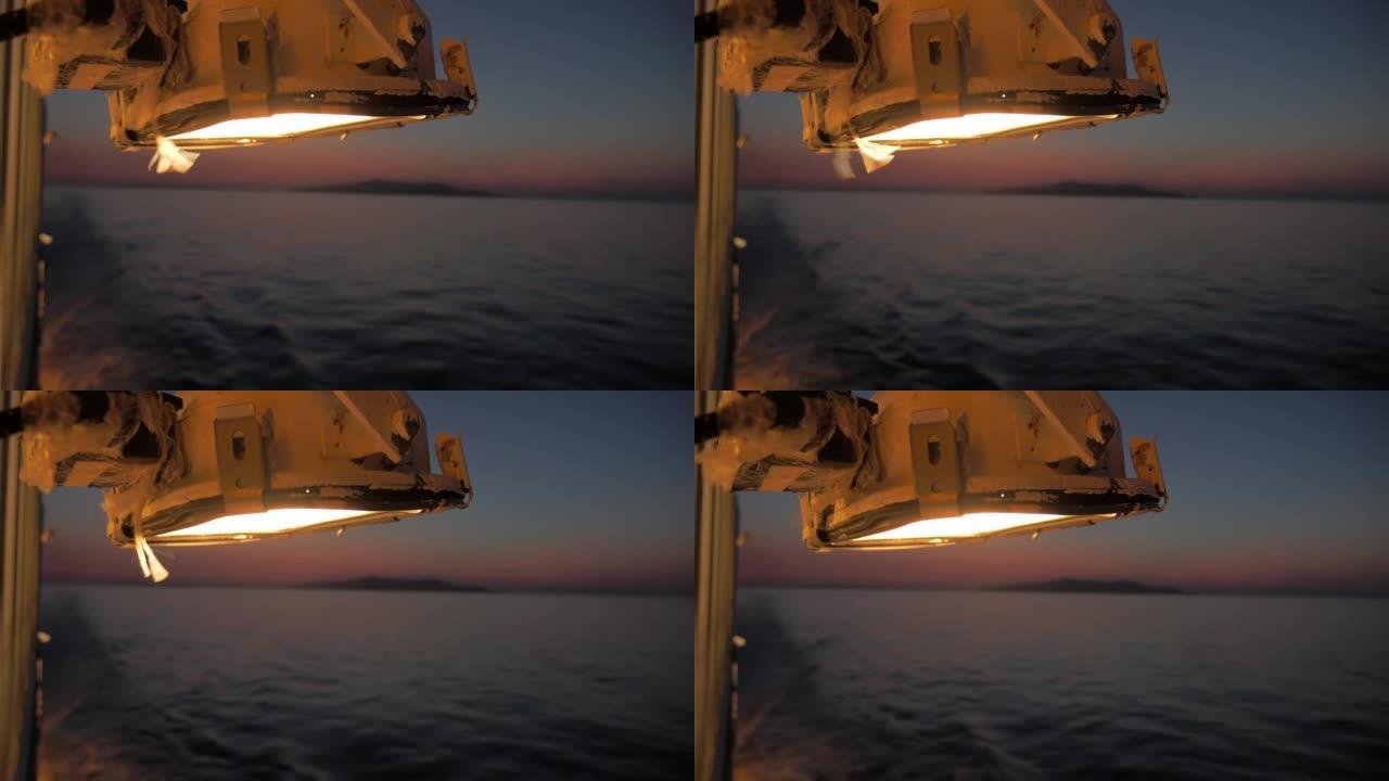 在海上日落时拍摄壮丽的全景，在夜间照明下，巡航刚刚离开比雷埃夫斯港方向前往阿莫戈斯
