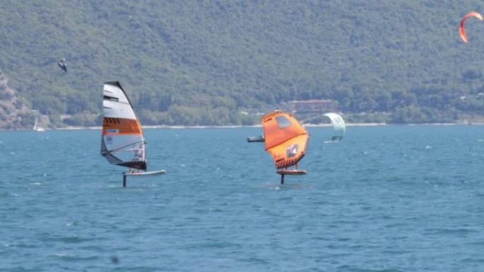 在刮风的晴天，湖上的一群机翼冲浪者的景色