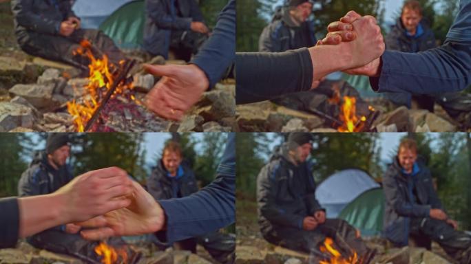 两个男人在森林里的篝火前做G锁握手