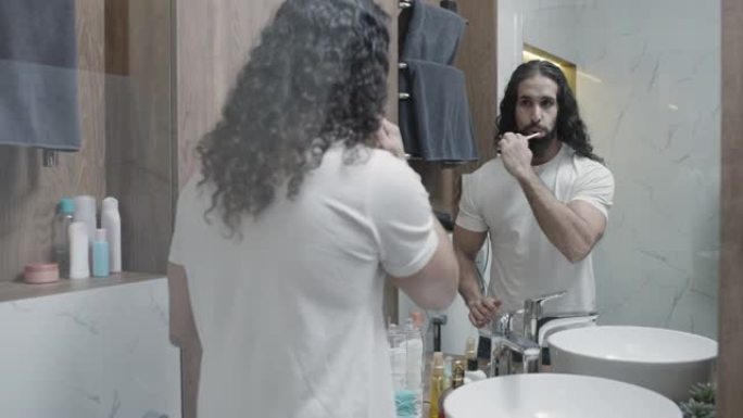 健康的男人早上刷牙，对着镜子微笑，牙齿卫生，健康