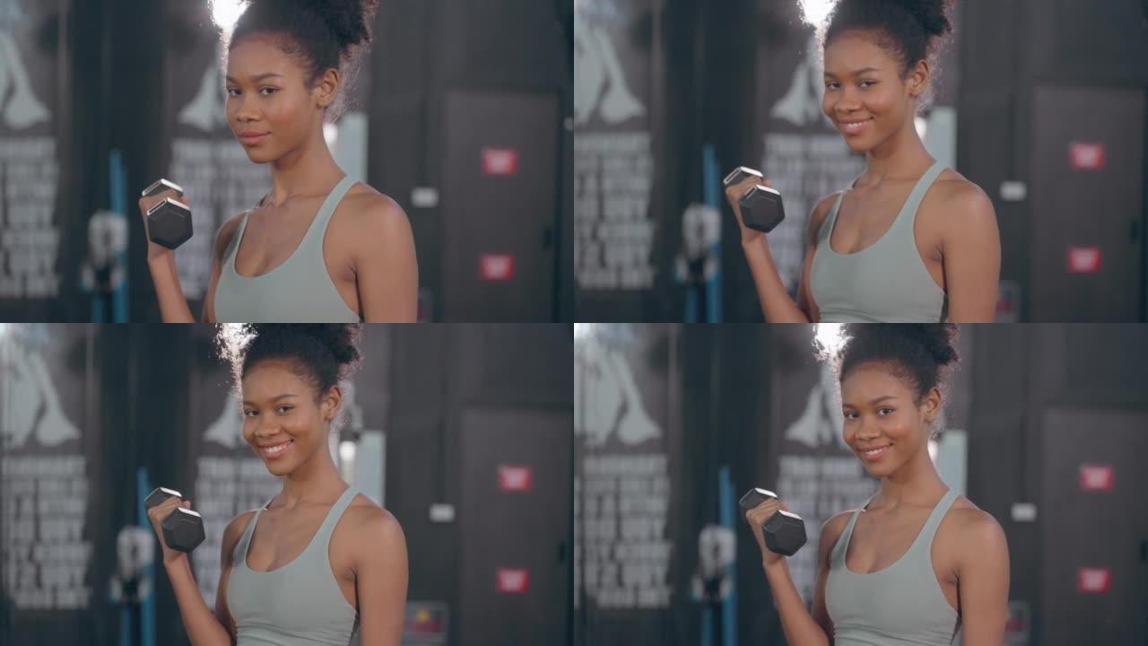 美丽迷人的非裔美国人女性在肱三头肌和肩部肌肉上做运动，固定室内电缆交叉。确定运动员在健身房锻炼