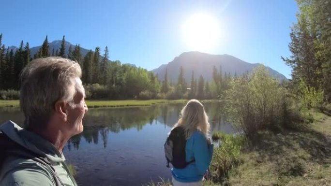 徒步旅行夫妇沿着山溪的边缘散步