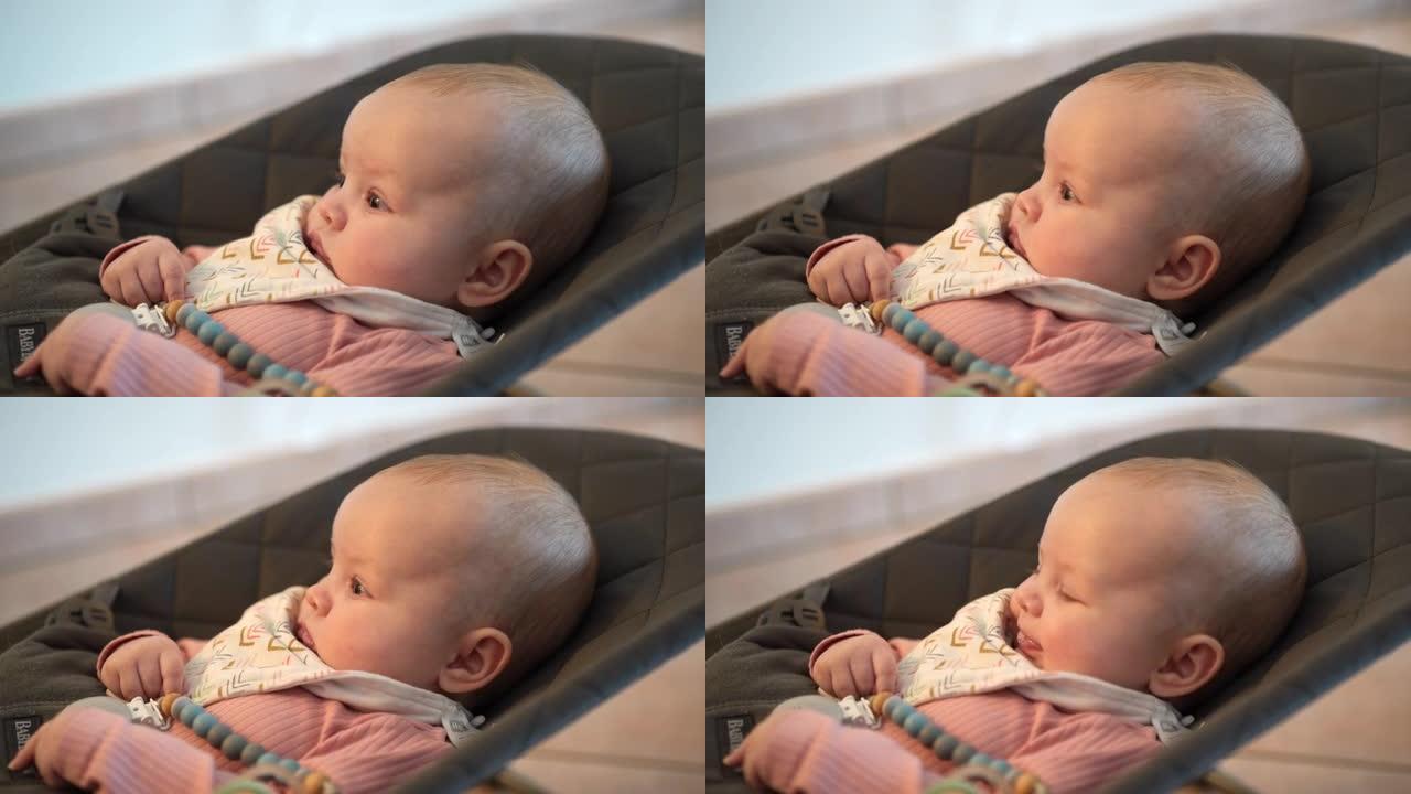 新生婴儿平静地坐在弹力椅上微笑