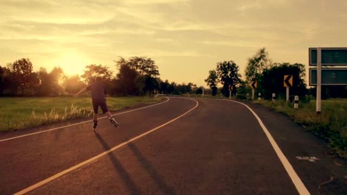 鸟瞰图，他在暮光之城的户外道路上玩直排轮滑。