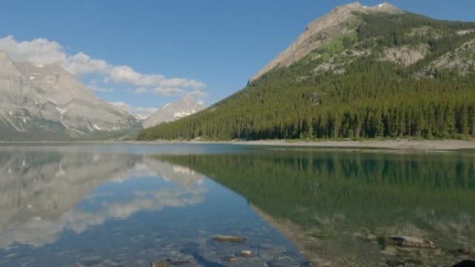 女人在山区湖岸享受时光，用智能手机拍照