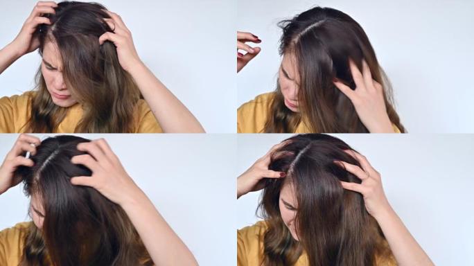 亚洲女人抓伤头皮造成头皮发痒。