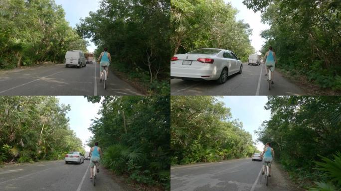 女人沿着丛林道路骑自行车