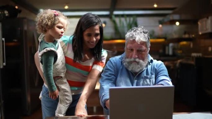 当女儿和外孙女到家时，祖父正在使用笔记本电脑
