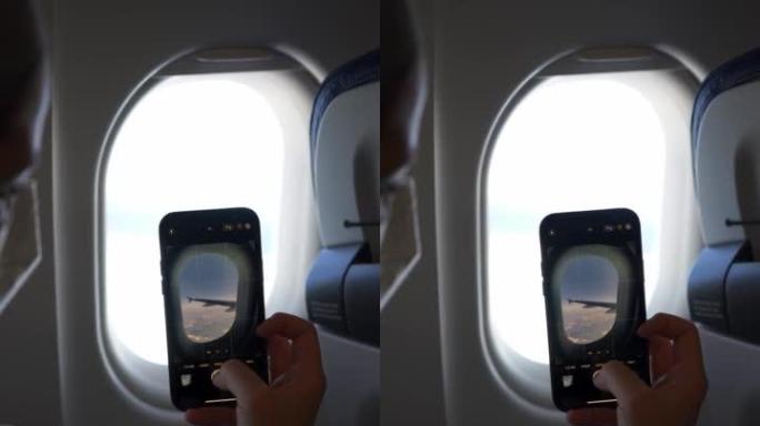 乘客在飞机上使用手机拍照的垂直细节照片