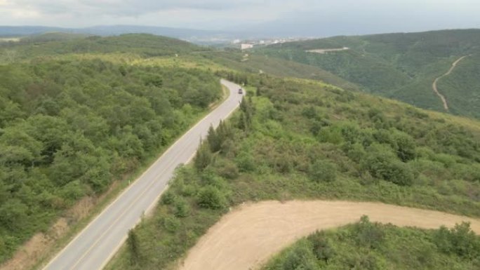 在森林道路上方飞行的鸟瞰图，单车行驶