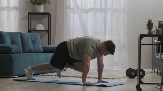 家庭健身房，男人正在锻炼身体肌肉，跑步和靠在地板上，使用运动垫，健身