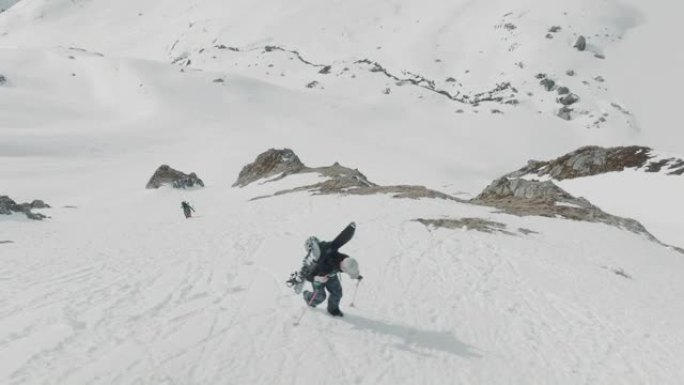 两名滑雪者在雪山上徒步旅行的空中无人机拍摄