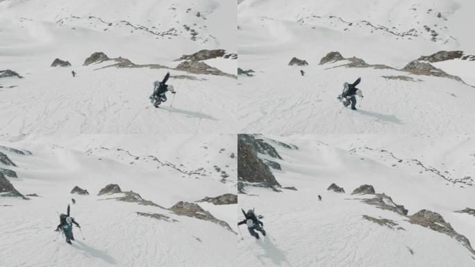 两名滑雪者在雪山上徒步旅行的空中无人机拍摄