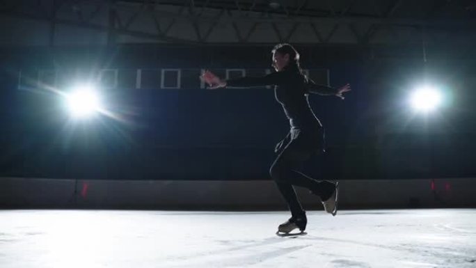 职业女子冰上花样滑冰运动员在室内溜冰场练习旋转，120 FPS慢动作
