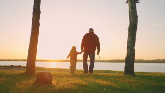 老人和他的孙子在大自然中旅行，在日落时步行到湖边钓鱼，后视