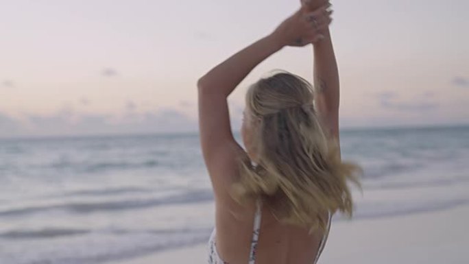 诱人的女人在镜头前跳舞和摆姿势。海滩上阳光明媚的日子