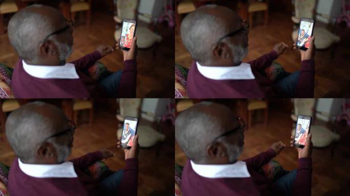 高级男子在家中通过手机进行视频通话